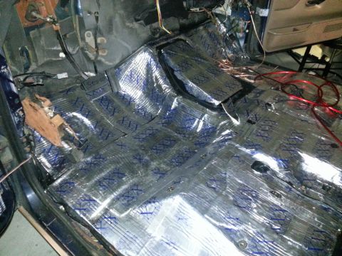 1994 Ford Bronco - Sound deadening material is applied to the interior floor of a vehicle, with wiring exposed.