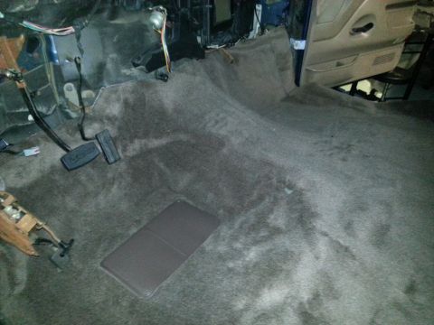 1994 Ford Bronco - View of the interior carpet and pedals, showing some wear and tear.