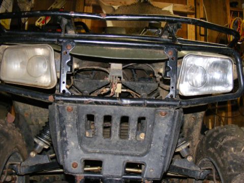Front view of a black ATV with two headlights and a black bumper.