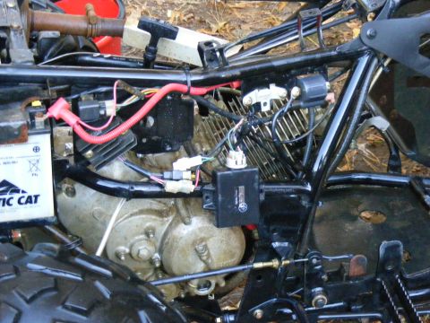 ATV engine, battery, and frame components. Some wiring is visible
