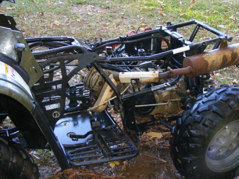 ATV frame and engine with rusty exhaust pipe