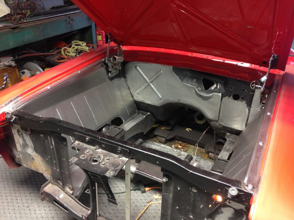 1964 Ford Fairlane engine bay with new metal panels and open hood.