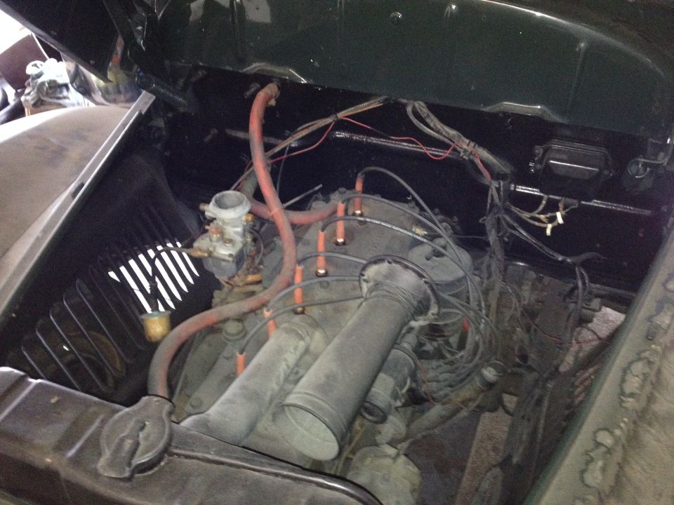 Engine bay of a classic International KB-1 with hood open, showing engine, carburetor, and wiring.
