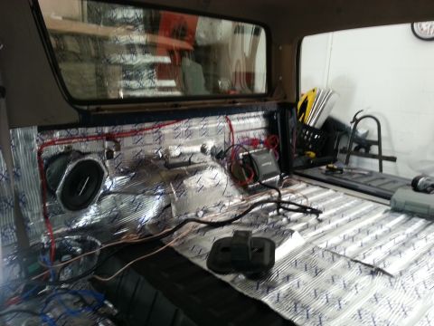 1994 Ford Bronco - Soundproofing installation in progress, showing speaker and wiring in a vehicle's interior.
