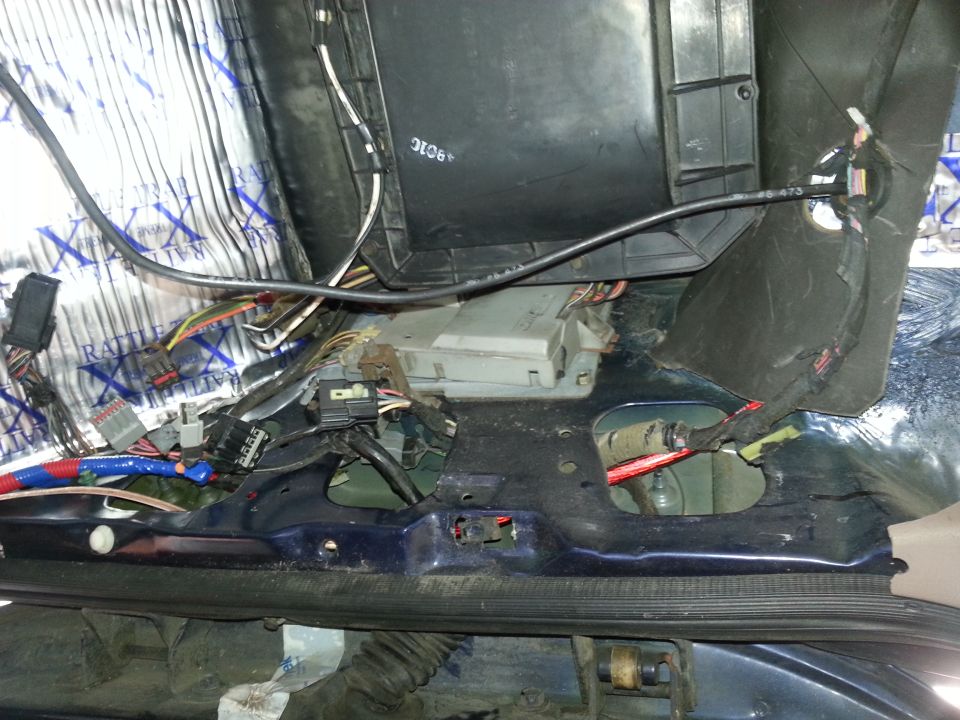 Under-dash view of HVAC box and wiring harnesses being serviced