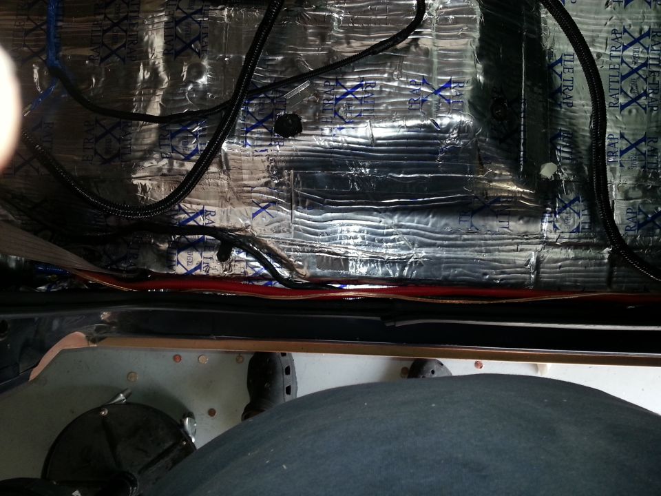 Photo of vehicle rocker area with sound-deadening mat and wiring runs
