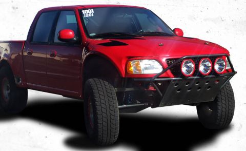 1988 Ford Bronco - A bright red, modified Ford F-150 pickup truck is shown from a 3/4 front angle. The truck features an off-road bumper with multiple lights…