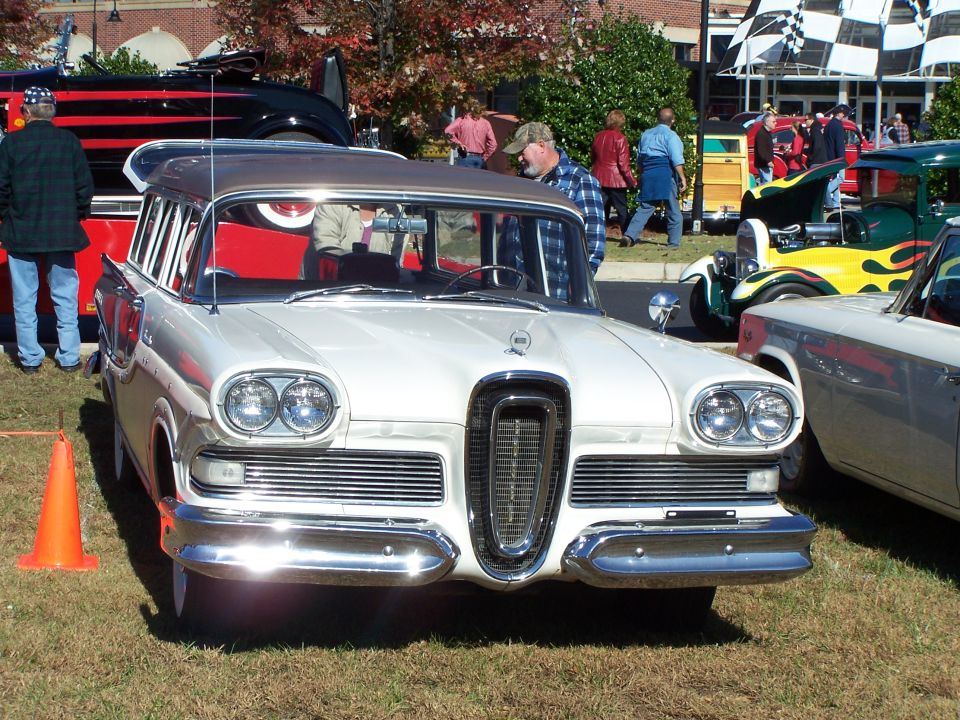 White 1958 Ford Fairlane 500 Skyliner with chrome grille and dual headlights, parked on grass