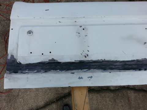 1992 Ford Bronco - Car door panel with rust repair work, including primer and sealant application.