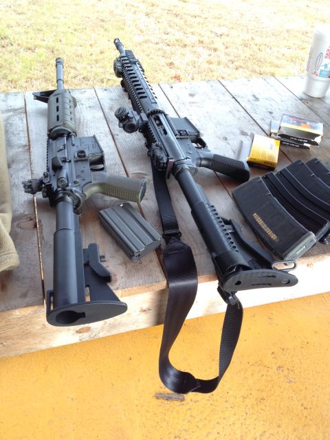 1982 Ford Bronco - Two rifles and several loaded magazines are laid out on a wooden surface.