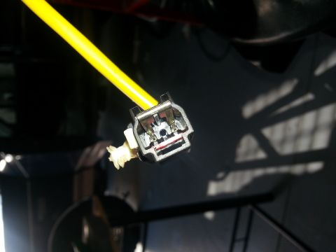 1994 Ford Bronco - Close-up of an automotive electrical connector with a bright yellow wire, revealing internal metal terminals.