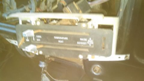 1979 Ford Bronco - Interior view of a vehicle's climate control panel, with visible wiring and labels for temperature and fan settings.