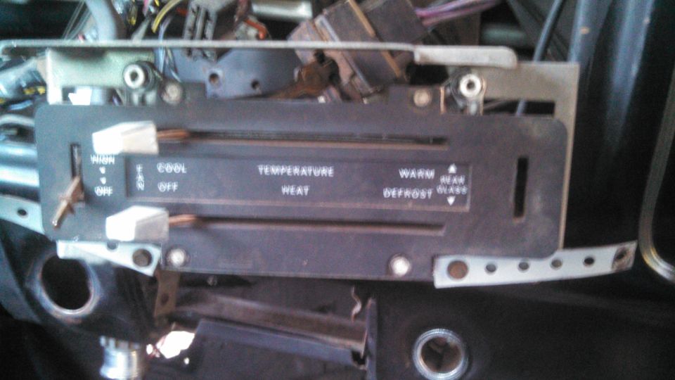 Vintage car climate control panel with labels for Cool, Warm, Defrost, High, Off, and Rear Glass.