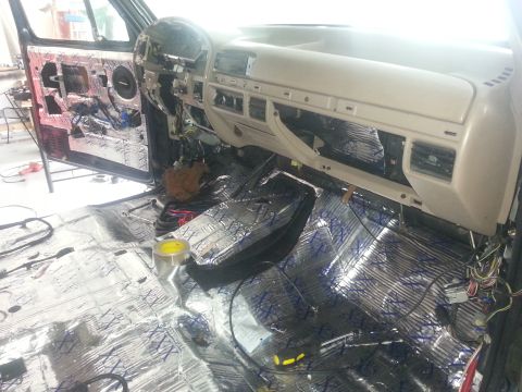 1994 Ford Bronco - Photograph of a truck interior with dashboard and foil sound-deadening across the floor, not a technical document.