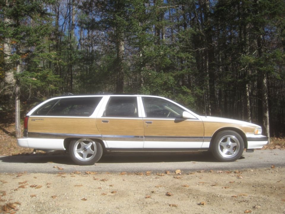 White 1995 Buick Roadmaster station wagon with wood paneling parked on a road.