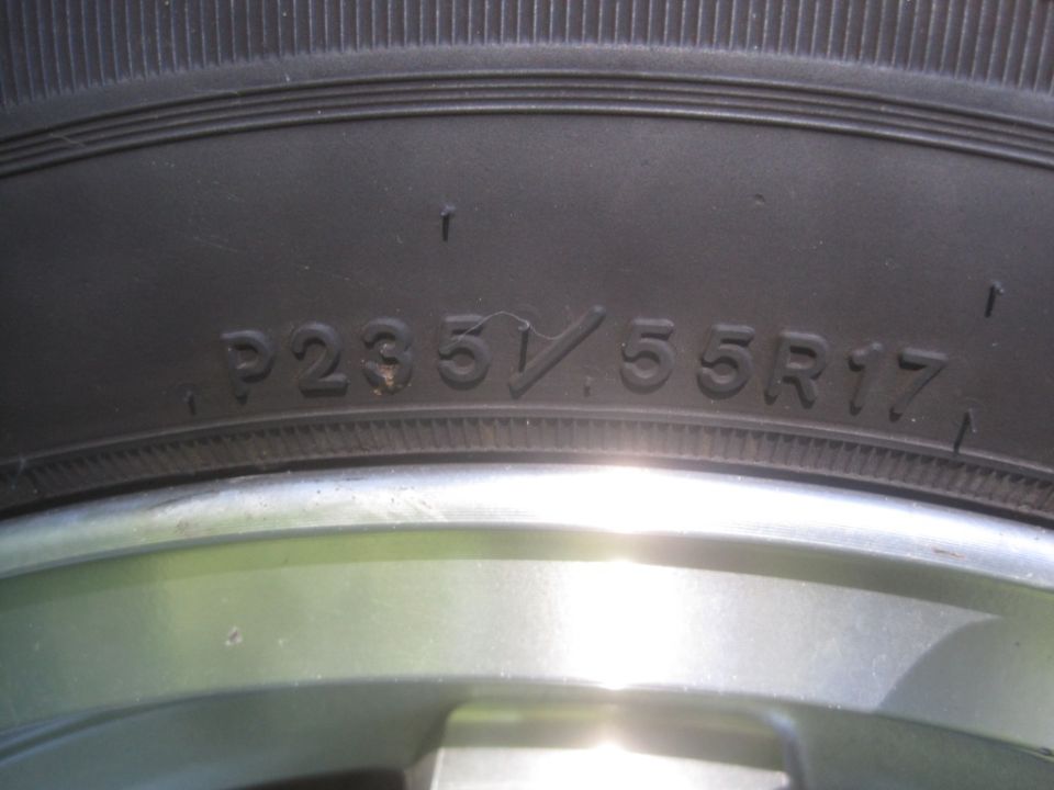 Close-up of tire sidewall text P235/55R17 and part of a silver wheel.