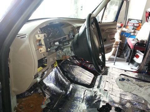 1994 Ford Bronco - Photograph of a truck driver footwell with steering wheel and foil sound-deadening, not a technical document.