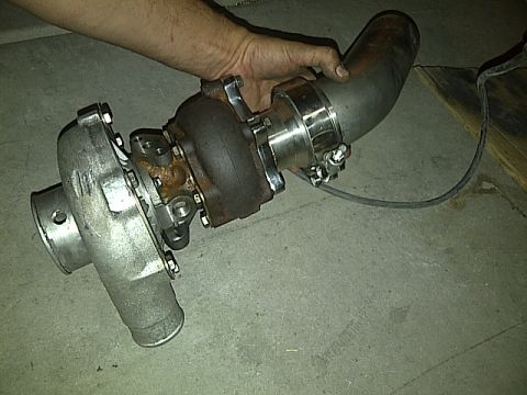 1995 Ford Probe - A person is holding a turbocharger with a cast aluminum compressor housing and a cast iron turbine housing. A stainless steel pipe is attac…