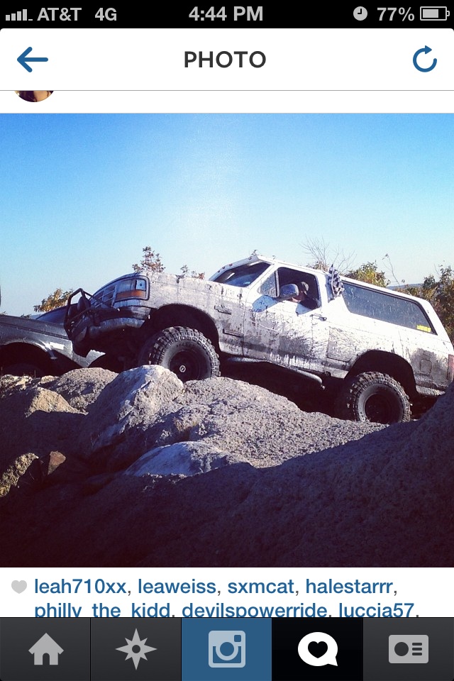 White Ford Bronco climbing rocks off-road.