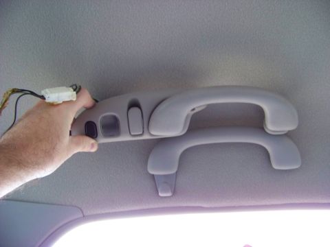 1999 Mercury Grand Marquis - Interior view of grab handles and overhead console with buttons and wires.