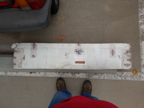 1965 Ford Mustang - A long, white cardboard box with "MAGNUM" tape is shown lying on a concrete surface. The box has some writing on it, including "1/2" and "2…