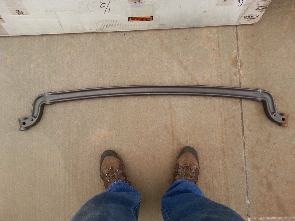 Dark gray sway bar with mounting brackets on concrete