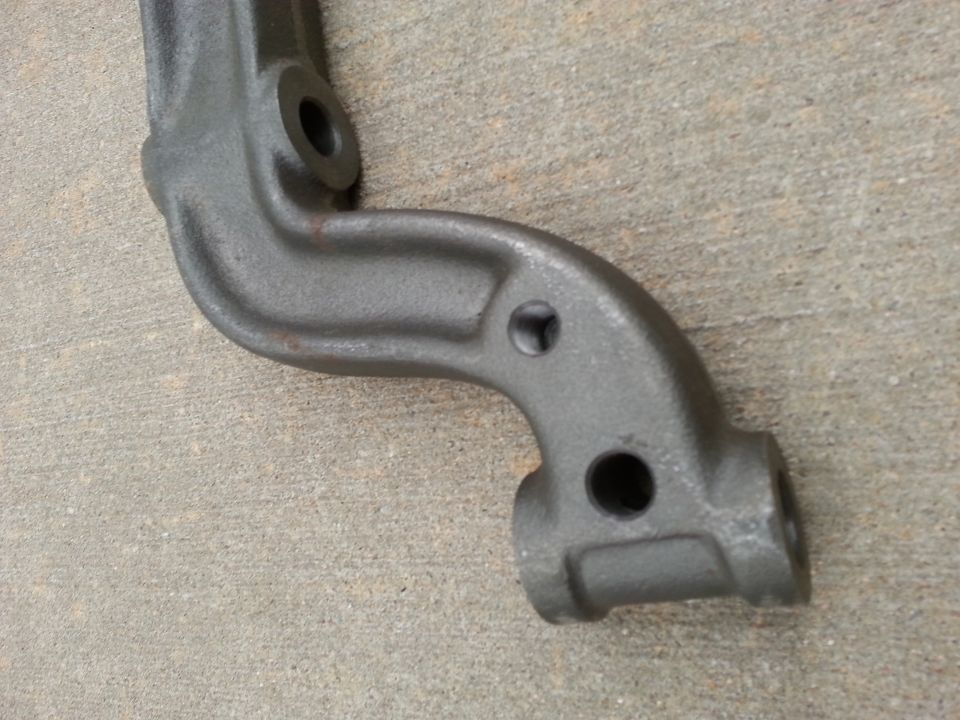 Gray metal automotive part with holes on concrete