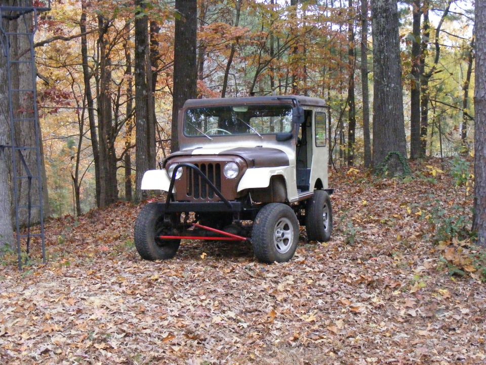 Custom Jeep CJ-5 with hardtop and brush guard in a forest setting.