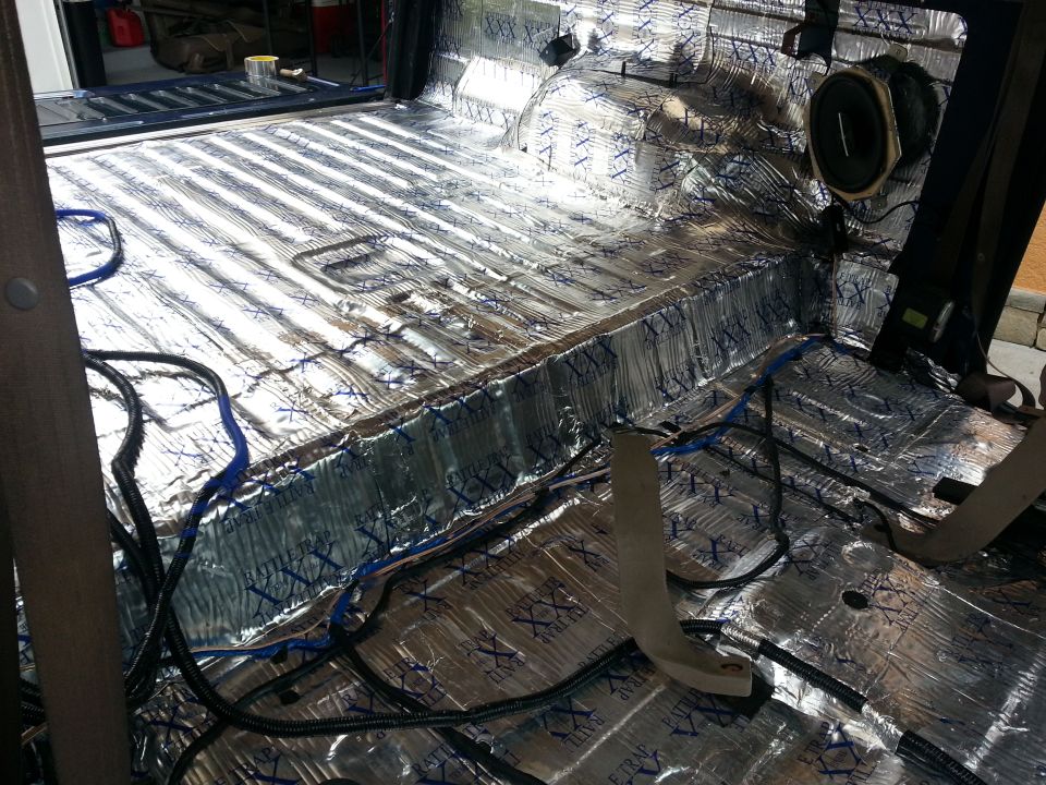 Photo of truck bed/cargo area lined with foil sound-deadening and wiring