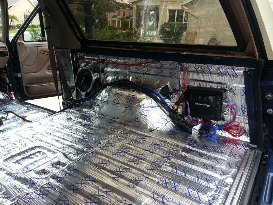 Vehicle interior with sound deadening material on floor and walls, speaker, and Pioneer amplifier