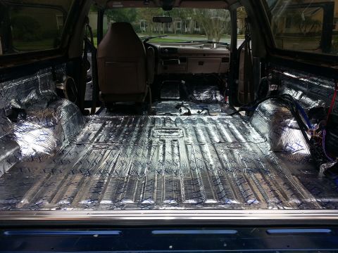 1994 Ford Bronco - The interior of a vehicle is shown with sound deadening material installed on the floor and rear cargo area.