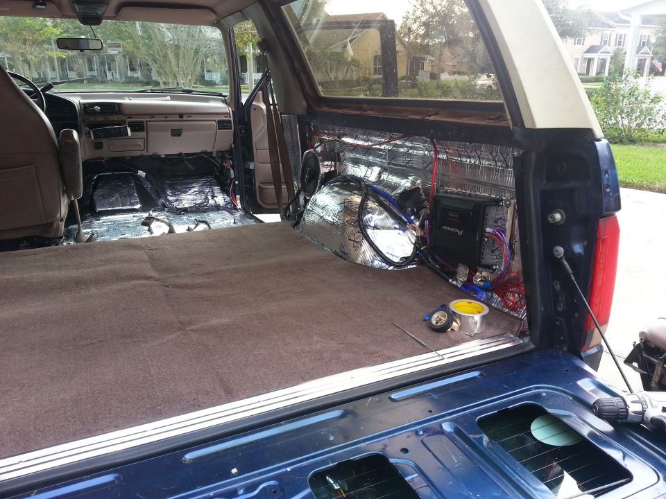 Photo of SUV cargo area with amplifier, wiring and sound-deadening