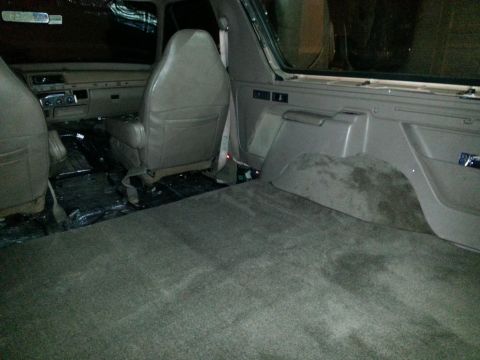 1994 Ford Bronco - Photograph of an SUV interior with seats, carpeting, and rear cargo wheel well.