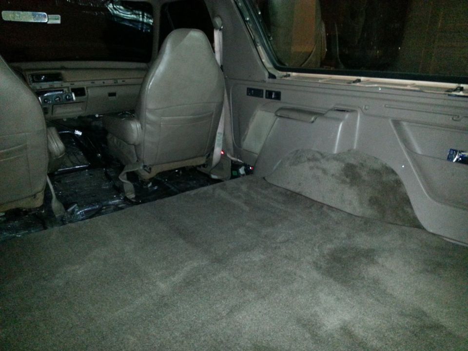 SUV interior showing seats, carpet, and rear cargo area