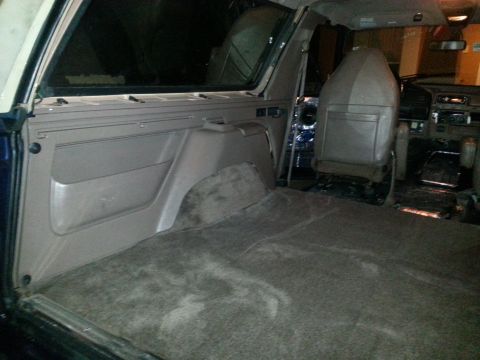 1994 Ford Bronco - Photograph of an SUV rear cargo interior showing carpet, wheel well, and front seats.