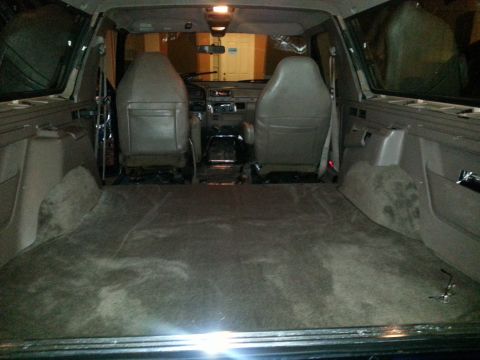 1994 Ford Bronco - Photograph of an SUV interior viewed from the rear cargo area toward the seats and dash.