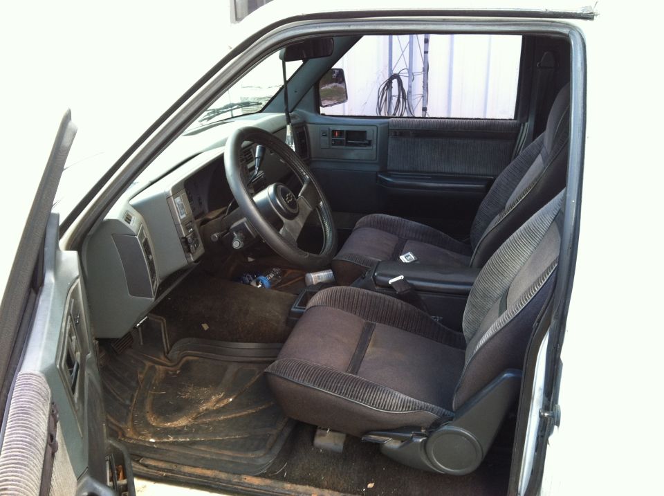 Interior view of a white Chevrolet Blazer showing the driver's seat, dashboard, and steering wheel.