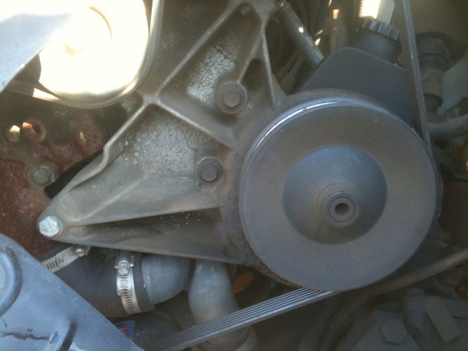 Close-up of power steering pump and pulley on a 1991 Ford Bronco engine.