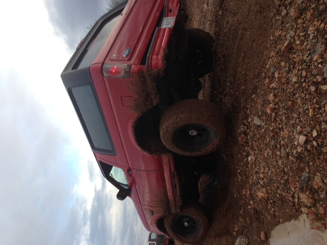 Red 1996 Ford Bronco in mud, 3q-front view
