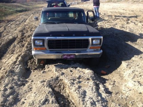 1979 Ford Bronco - Ford Bronco stuck in sand, with another vehicle visible in the background.