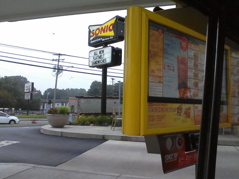 Sonic Drive-In menu board with "All New Flatmelt Sandwiches" sign