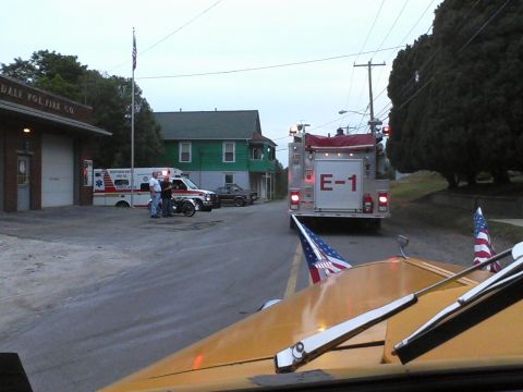 1935 Chevrolet New - Emergency vehicles are parked outside a fire station, with American flags visible on the foreground vehicle.