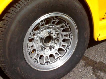 1935 Chevrolet New - A close-up view of a custom alloy wheel and tire on a yellow vehicle.
