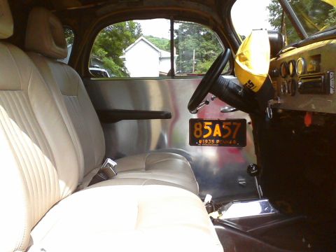1935 Chevrolet New - The interior of a 1935 Chevrolet New is visible, beige upholstery and a license plate from 1935.