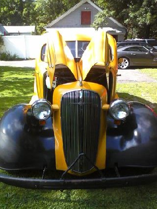 1935 Chevrolet New - A yellow and black 1935 Chevrolet is parked outdoors with its hood open.