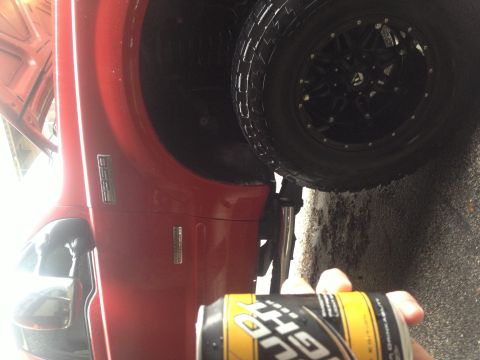 2007 Ford F-350 - Close-up of a red 2007 Ford F-350 fender and wheel with a Bud Light can in the foreground.