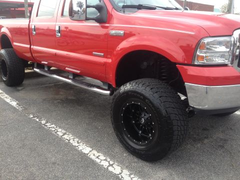 2007 Ford F-350 - This red 2007 Ford F-350 pickup truck is equipped with custom wheels and side steps.