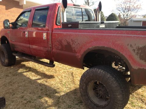2007 Ford F-350 - This red 2007 Ford F-350 pickup truck has been modified with large exhaust stacks and toolboxes in the bed.