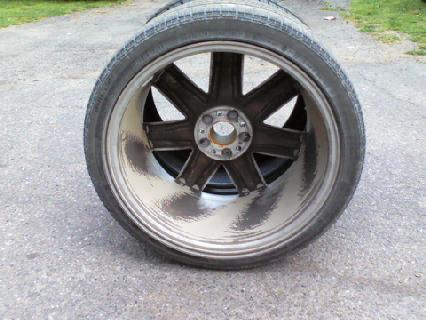 2004 Chrysler Crossfire - A single wheel and tire assembly is shown from the side, resting on asphalt.