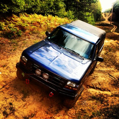 1996 Ford Bronco - 1996 Ford Bronco navigating a dirt path through a wooded area.